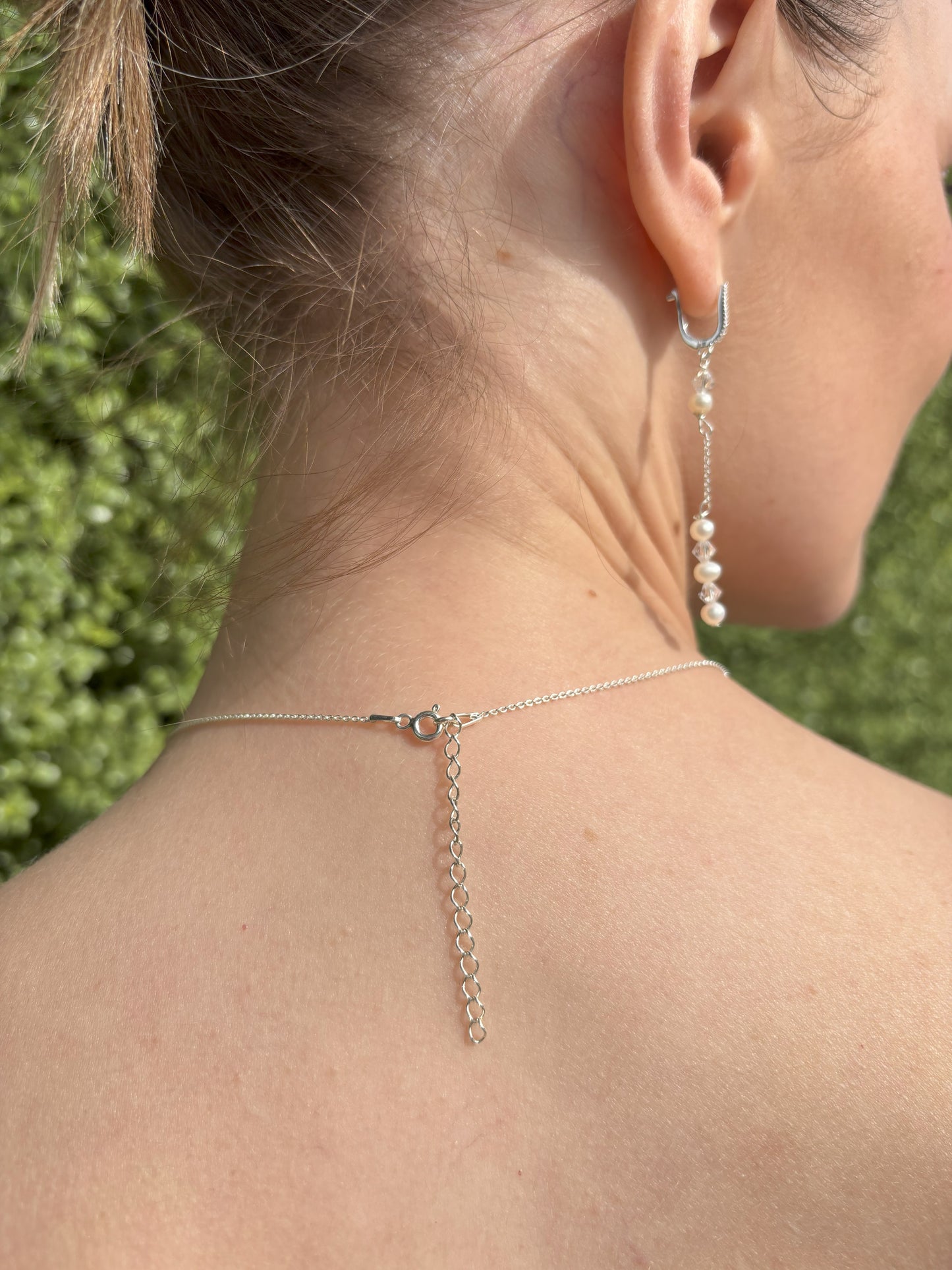 Back of waterfall drop necklace shown with the drops removed. Sterling silver chain is adjustable from 16 to 18 inch. If you prefer the shorter length, the extention is easily removed with wire cutters. Also shown are the freshwater pearl and crystal earrings, suspended from sterling silver hopps studed with the tiniest of crystals.