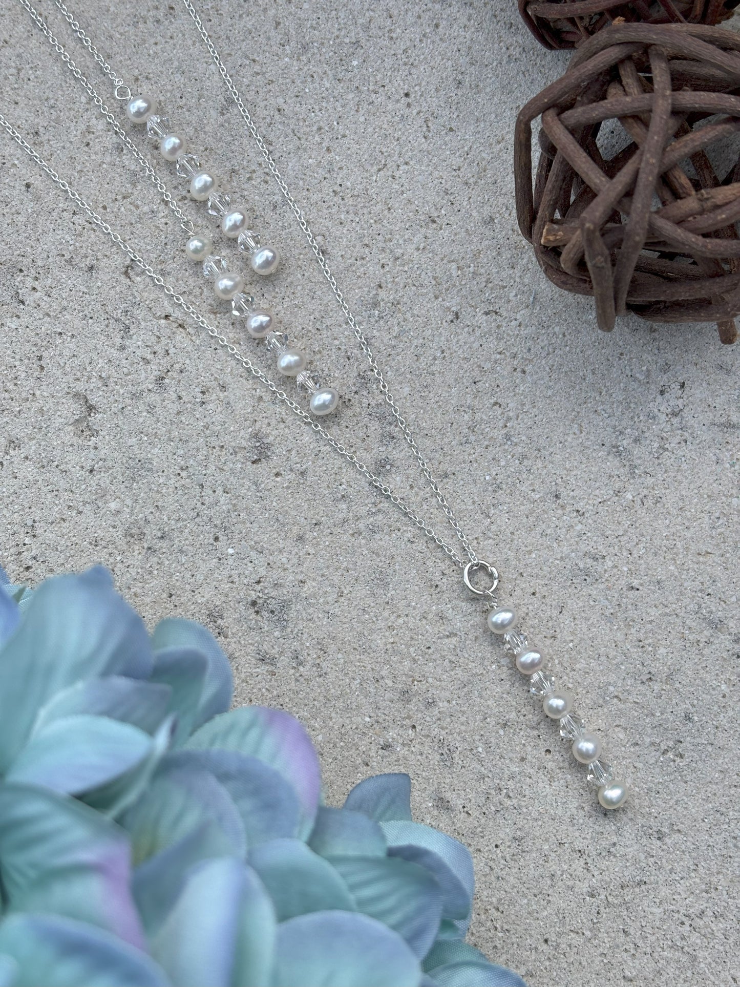 Pearl and crystal back drop necklace with matching drops front and back to form a waterfall back. The back draps are easily detachable from the adjustable sterling silver chain.