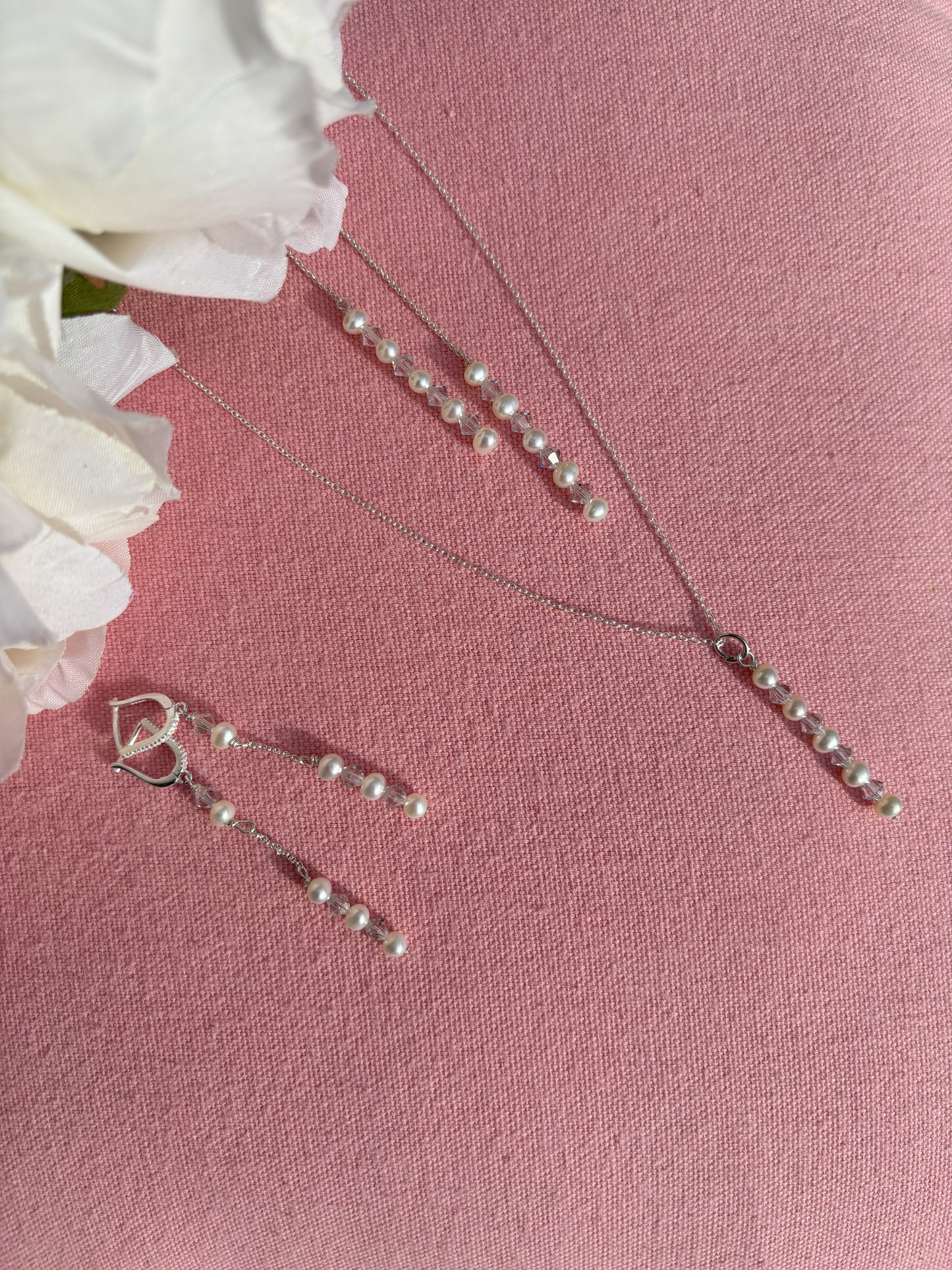 Pearl and crystal drop with waterfall back suspended from sterling silver chain. Shown with matching sterling silver hooped earrings and matching pearl and crystal drops. Earring hoops have small crystals.