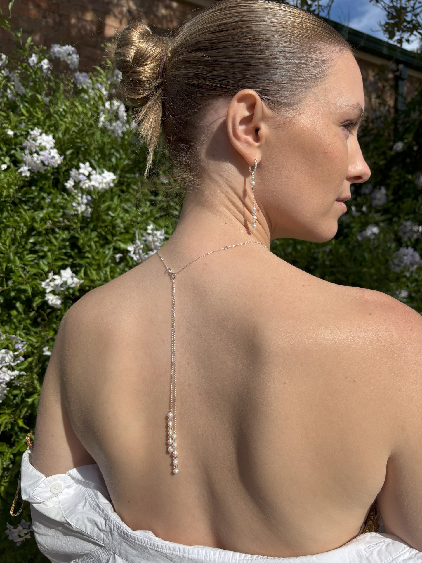 Back of waterfall drop necklace shown with the drops removed. Sterling silver chain is adjustable from 16 to 18 inch. If you prefer the shorter length, the extention is easily removed with wire cutters. Also shown are the freshwater pearl and crystal earrings, suspended from sterling silver hopps studed with the tiniest of crystals.