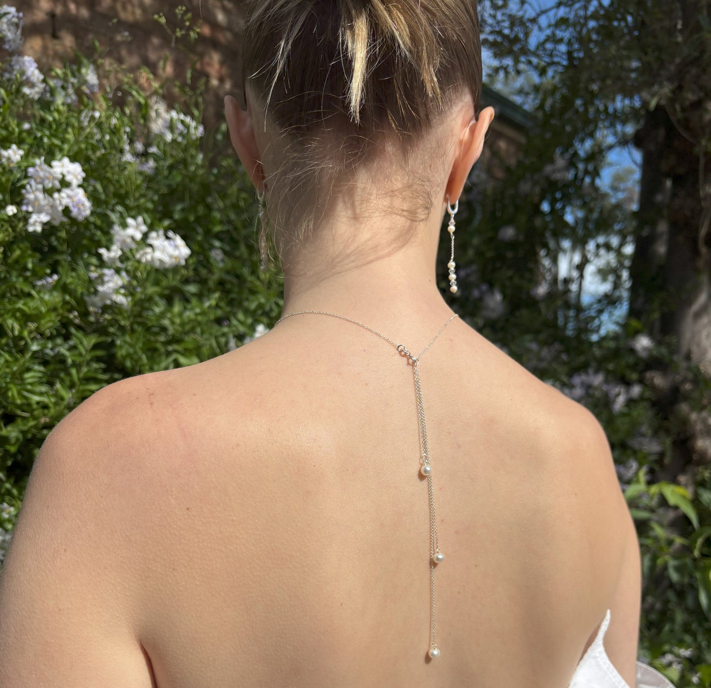 Three freshwater pearls form an elegant back drop feature to this sterling silver bridal necklace. The sterling silver chain is adjustable and the back drop pearls are easily removed for you to wear the necklace in traditional style.