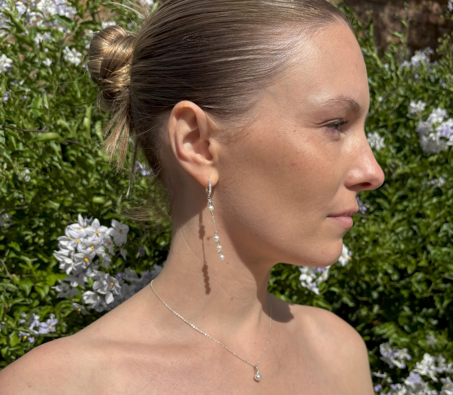 Pearl and crystal earrings using 4mm freshwater pearls and highest quality crystals (also 4mm). The earrings are suspended from sterling silver hoops studded with tiny crystals to reflect the light. Shown worn with our pearl back drop necklace.