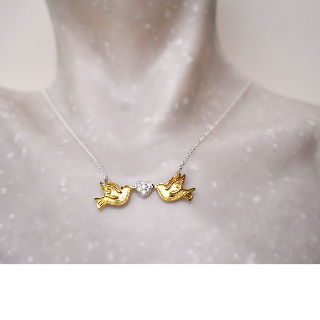 Sterling silver gold plated lovebirds are linked by each holding a sterling silver heart studded with small circonas, suspended from a sterling silver chain.