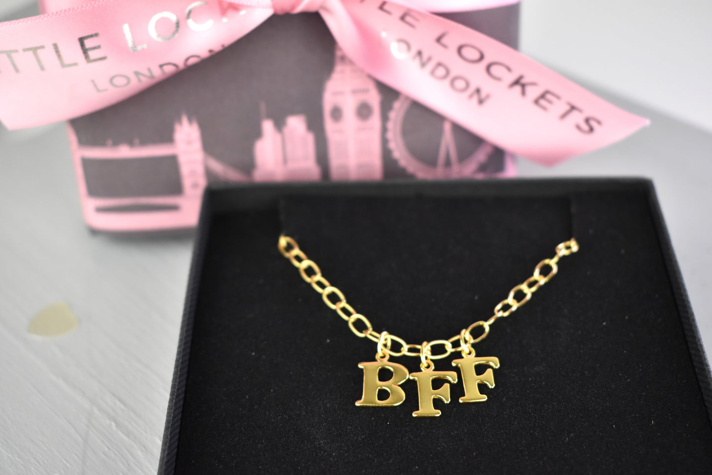 Model wears Necklace chain with and letters. Crafted with a 5.5mm link size chain in gold vermeil with serif letters spelling out BFF (Best Friends Forever). Each letter is a classic serif uppercase font.