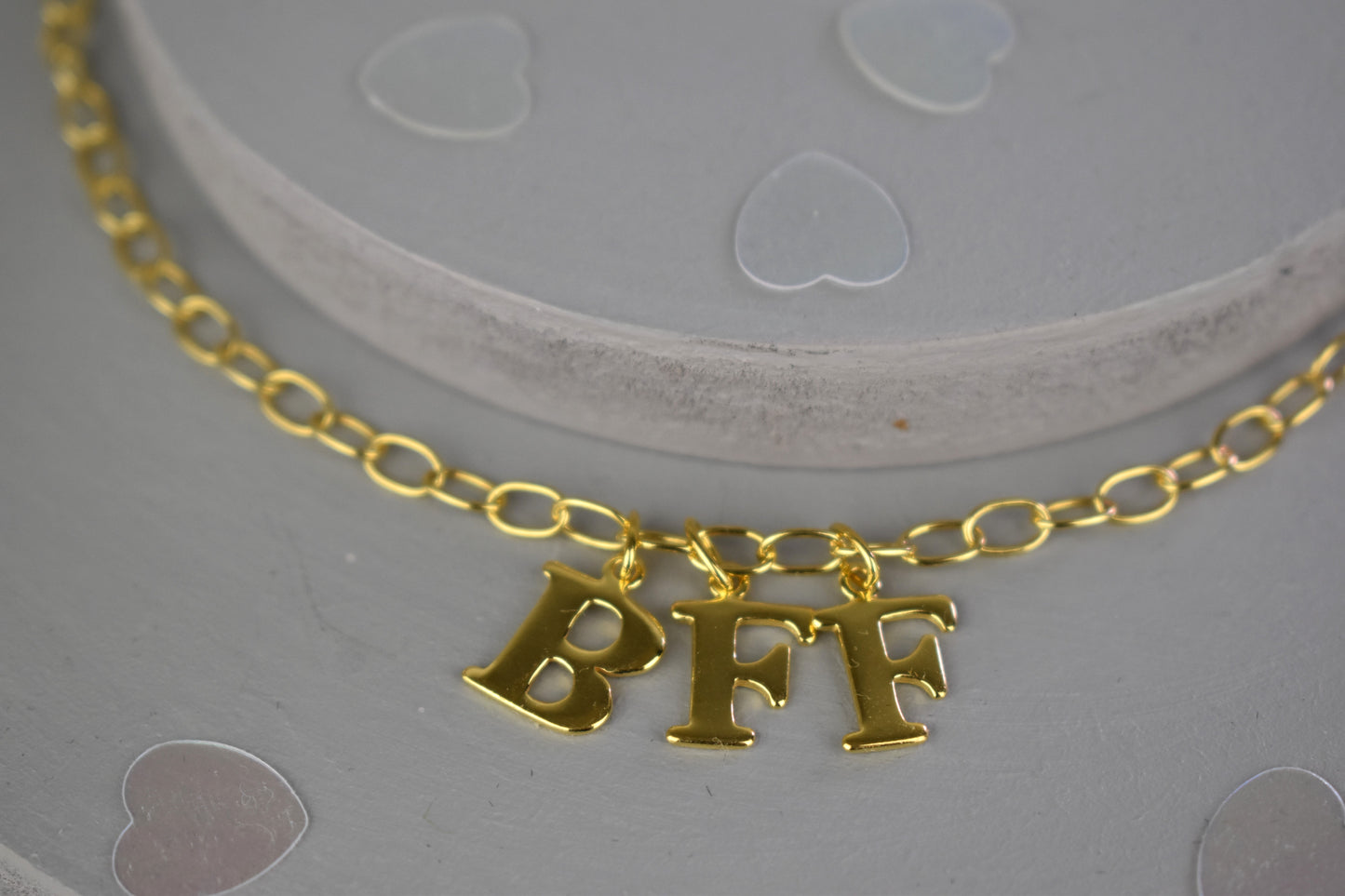 Model wears Necklace chain with and letters. Crafted with a 5.5mm link size chain in gold vermeil with serif letters spelling out BFF (Best Friends Forever). Each letter is a classic serif uppercase font.