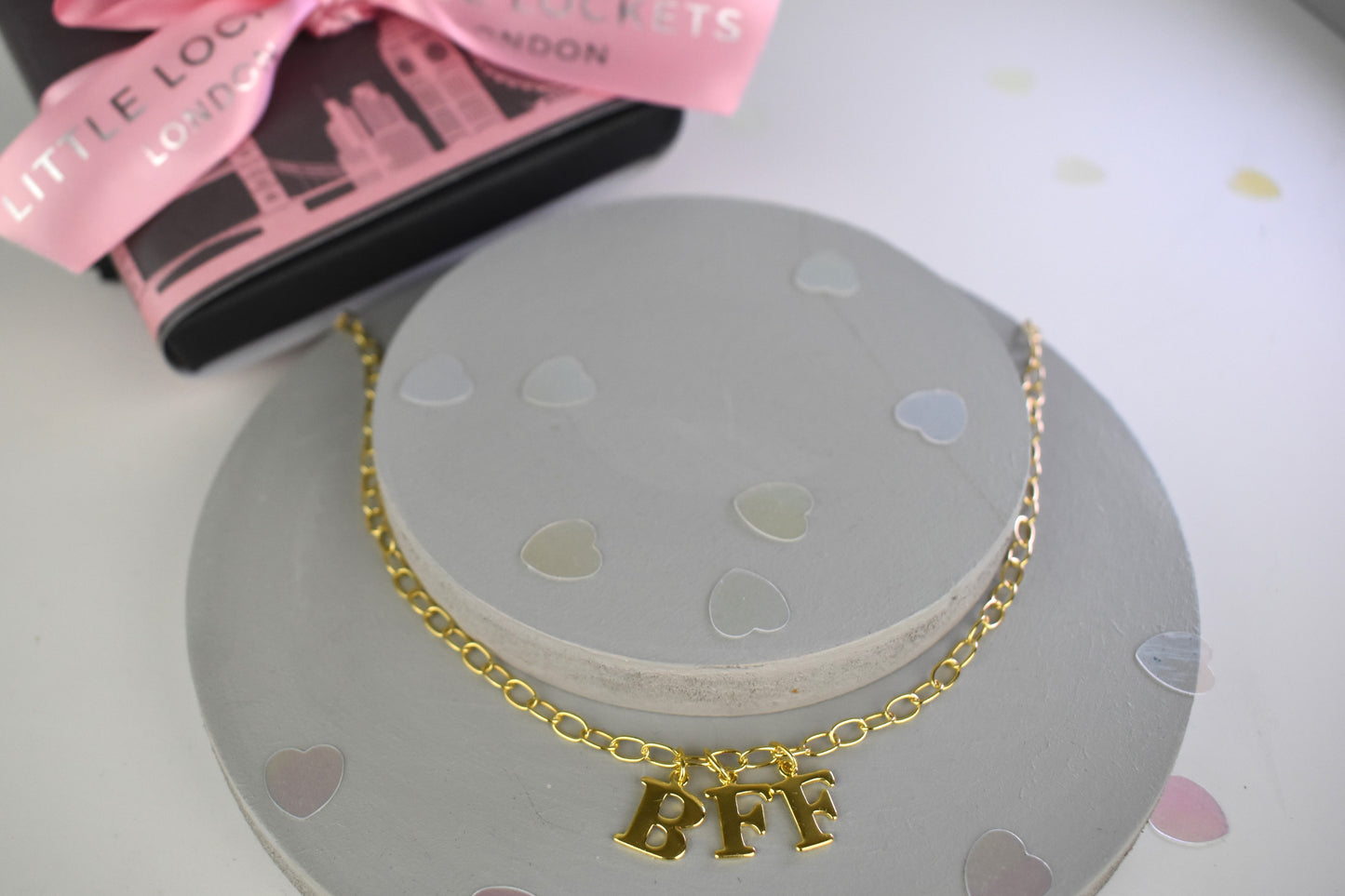 Model wears Necklace chain with and letters. Crafted with a 5.5mm link size chain in gold vermeil with serif letters spelling out BFF (Best Friends Forever). Each letter is a classic serif uppercase font.