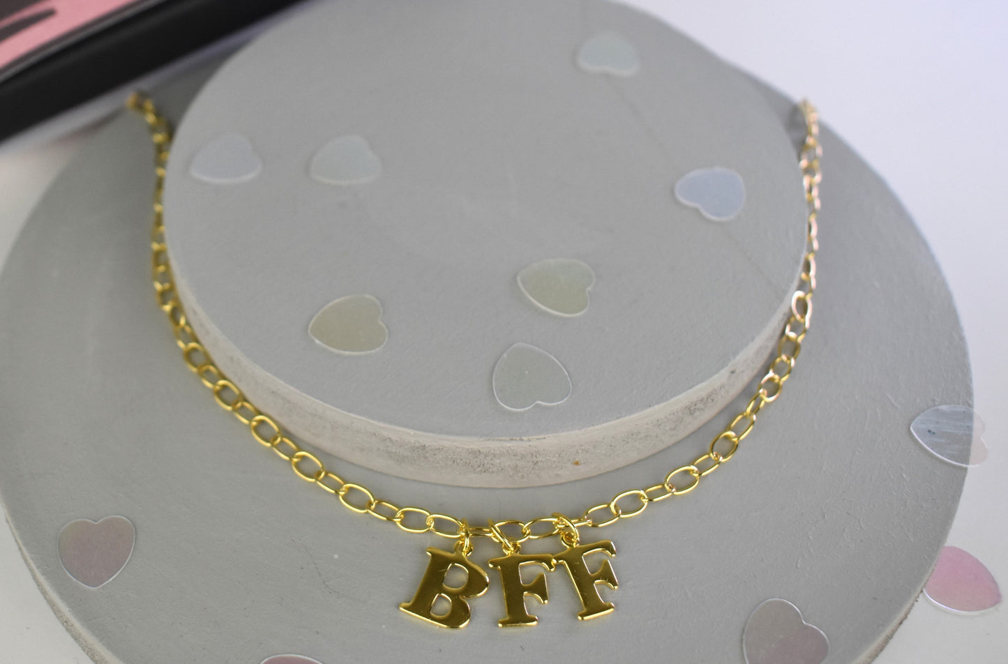 Model wears Necklace chain with and letters. Crafted with a 5.5mm link size chain in gold vermeil with serif letters spelling out BFF (Best Friends Forever). Each letter is a classic serif uppercase font.