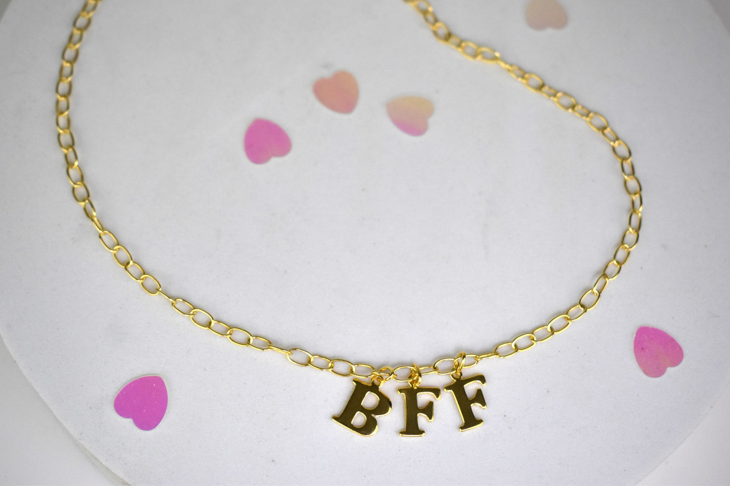 Model wears Necklace chain with and letters. Crafted with a 5.5mm link size chain in gold vermeil with serif letters spelling out BFF (Best Friends Forever). Each letter is a classic serif uppercase font.