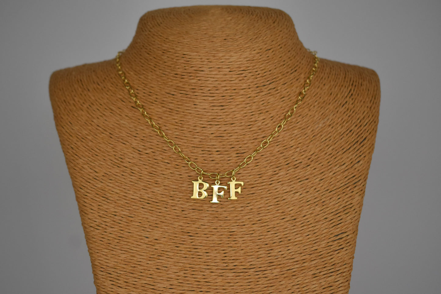 Model wears Necklace chain with and letters. Crafted with a 5.5mm link size chain in gold vermeil with serif letters spelling out BFF (Best Friends Forever). Each letter is a classic serif uppercase font.