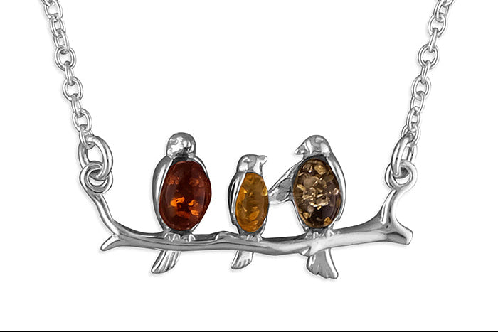 Sterling silver connector necklace showing three birds on a branch. The birds are inlaid with three types of amber - honey, cognac and olive.
