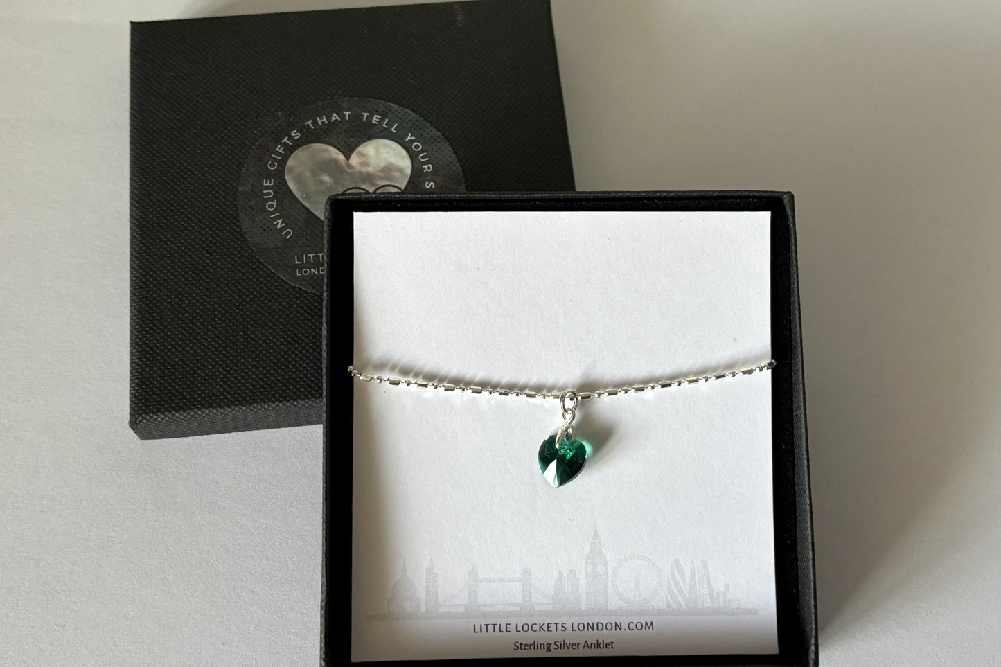 mirror link anklet with birthstone coloured crystal heart shown in branded gift box