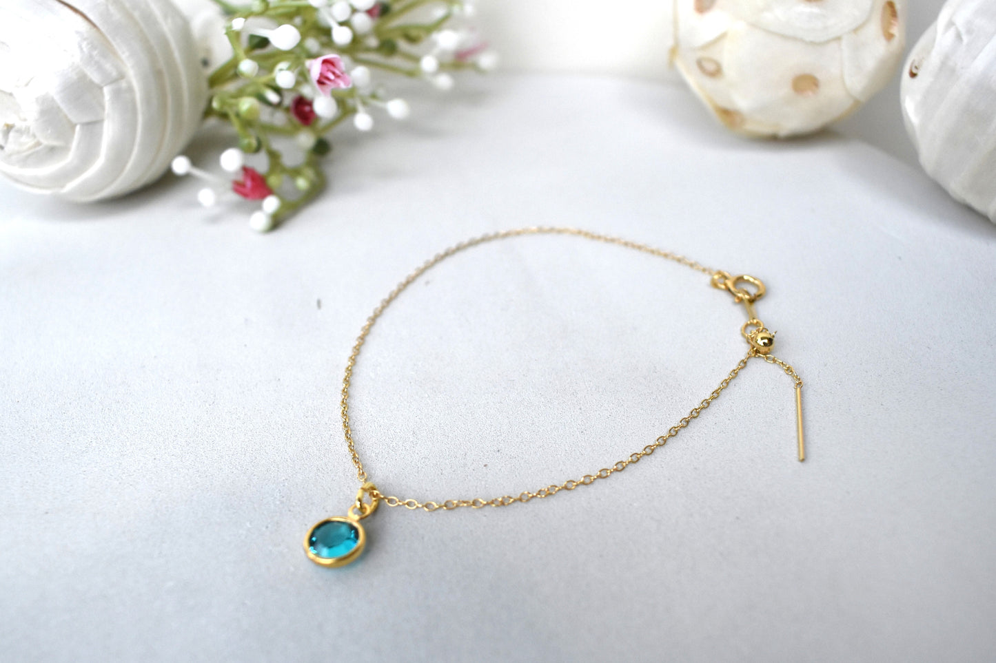 A gold filled chain is threaded through a bead to make this delicate bracelet adjustable. Finished with a birthstone of your choice, ths bracelet is the perfect summer accessory.