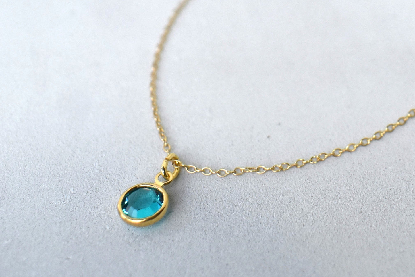 A gold filled chain is threaded through a bead to make this delicate bracelet adjustable. Finished with a birthstone of your choice, ths bracelet is the perfect summer accessory.