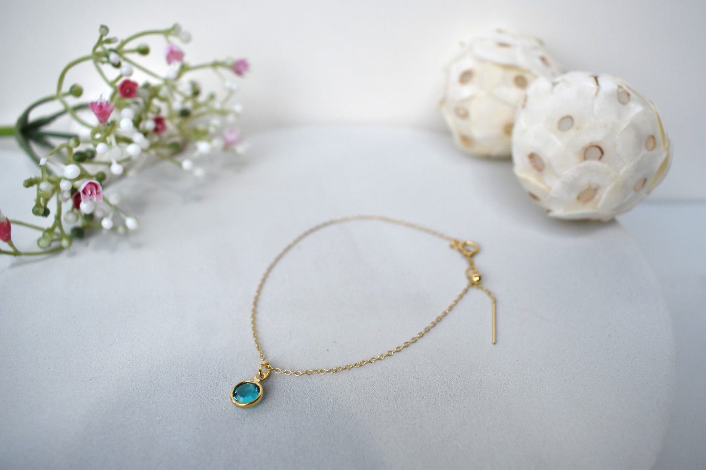 A gold filled chain is threaded through a bead to make this delicate bracelet adjustable. Finished with a birthstone of your choice, ths bracelet is the perfect summer accessory.