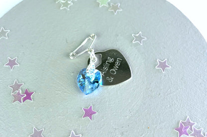 secret something blue pin shown in sterling silver and with an accompany sterling silver heart engraved with the couple's names.