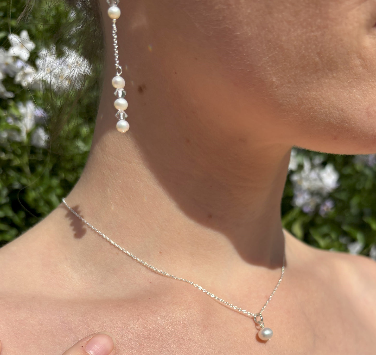 Pearl and crystal earrings using 4mm freshwater pearls and highest quality crystals (also 4mm). The earrings are suspended from sterling silver hoops studded with tiny crystals to reflect the light. Shown worn with our pearl back drop necklace.