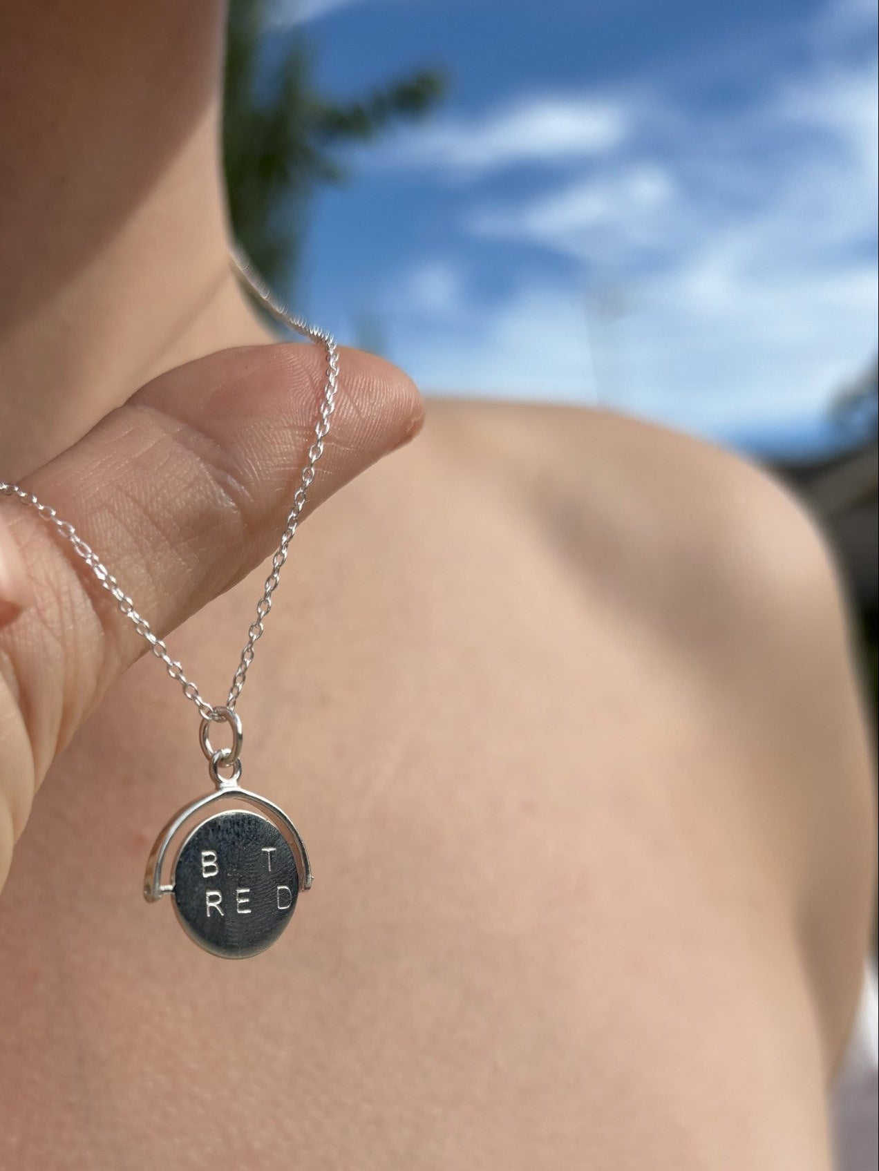 Sterling silver spinner necklace with lettering either side. When spon is forms the words "Best Friend"