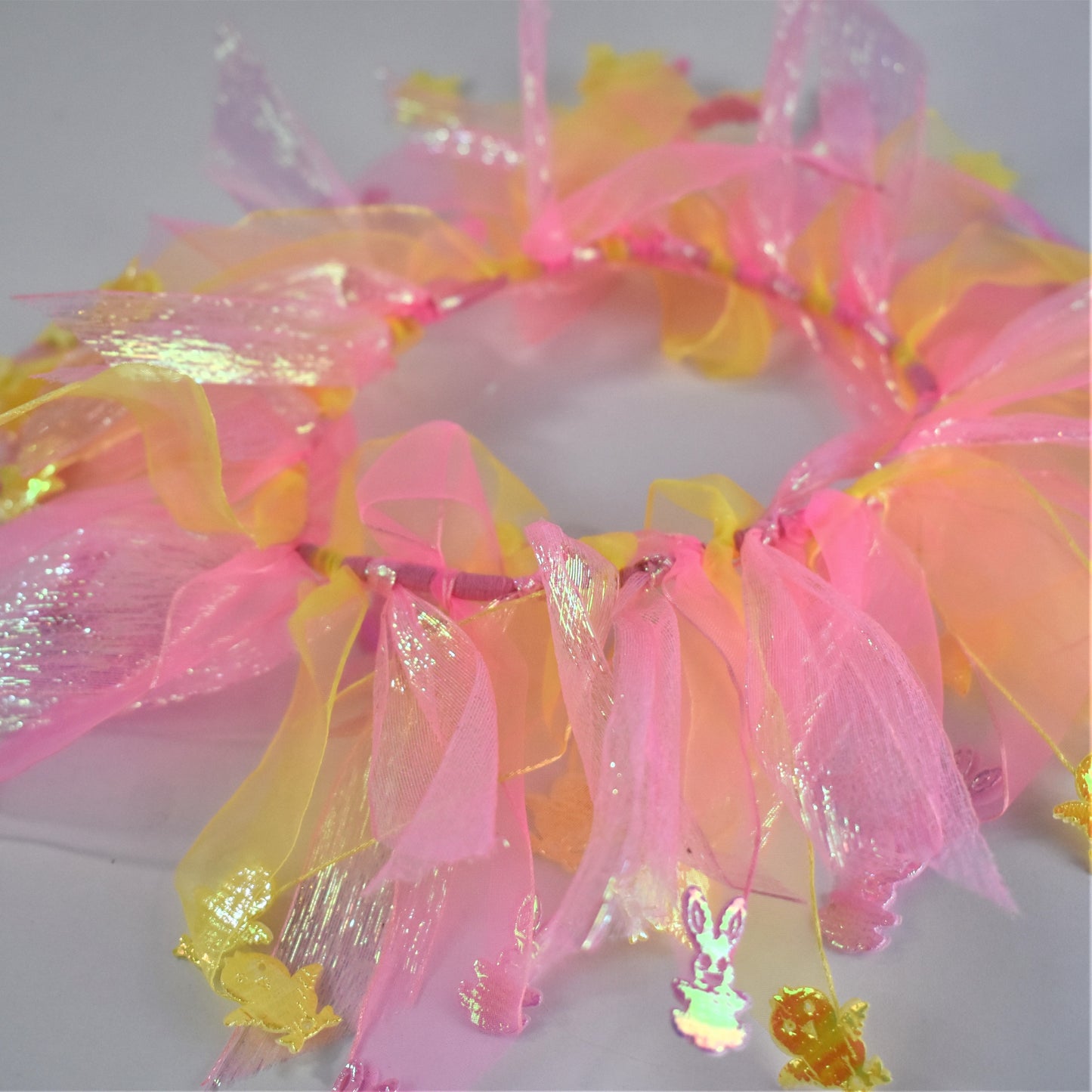 Worn by medium size cockapoo. Fun elastic frill for dogs. Pastel pink and yellow tulle frills with foil pink rabbits and yellow chicks on the end of each tulle frill. One size.