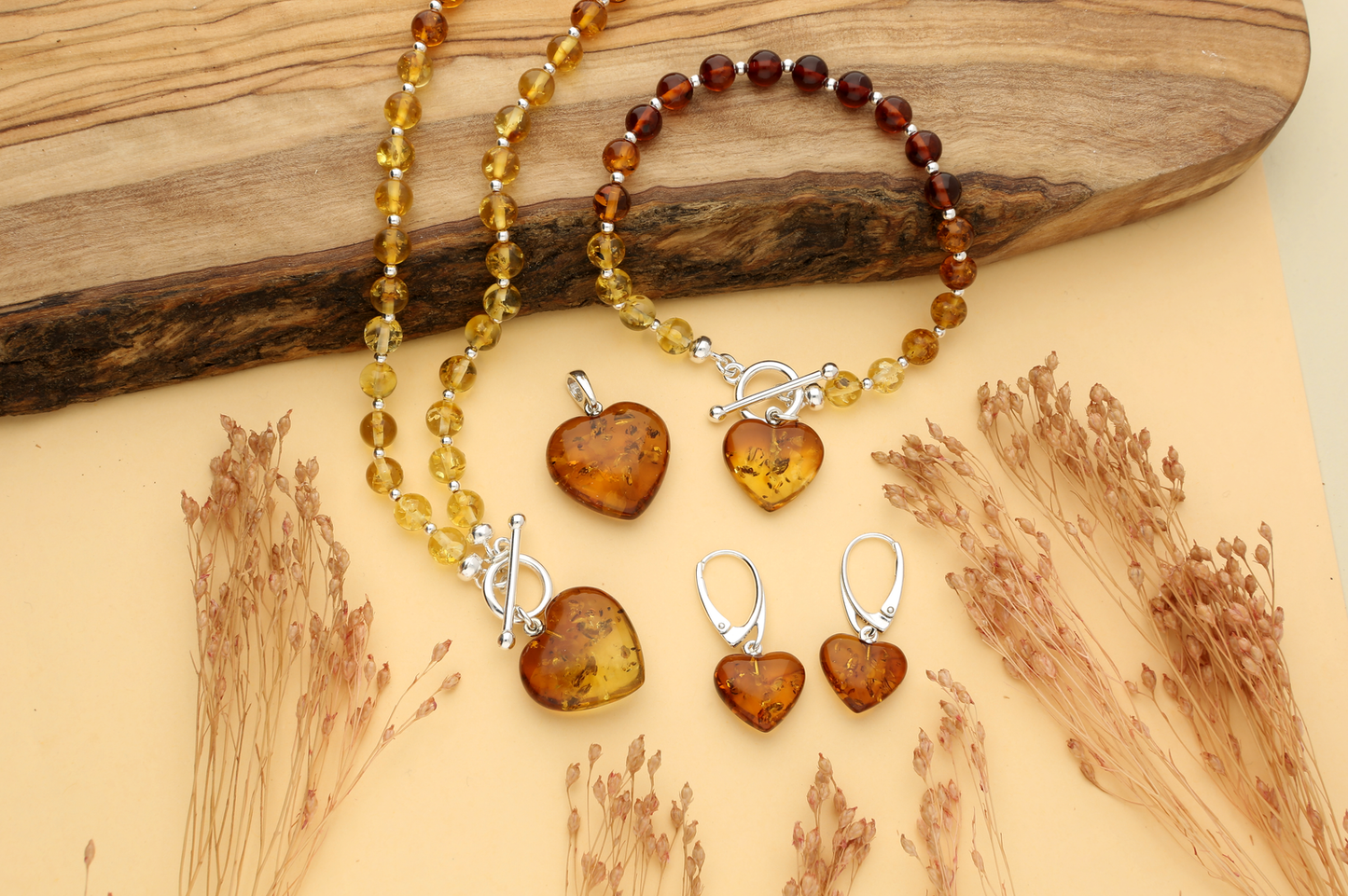 Cognac amber bead collection - graduated amber bead bracelet with amber heart charm, matching graduated amber bead necklace, cognac amber heart pendant with sterling silver bail and sterling silver lever gack hearings with a dangling cognac amber heart.