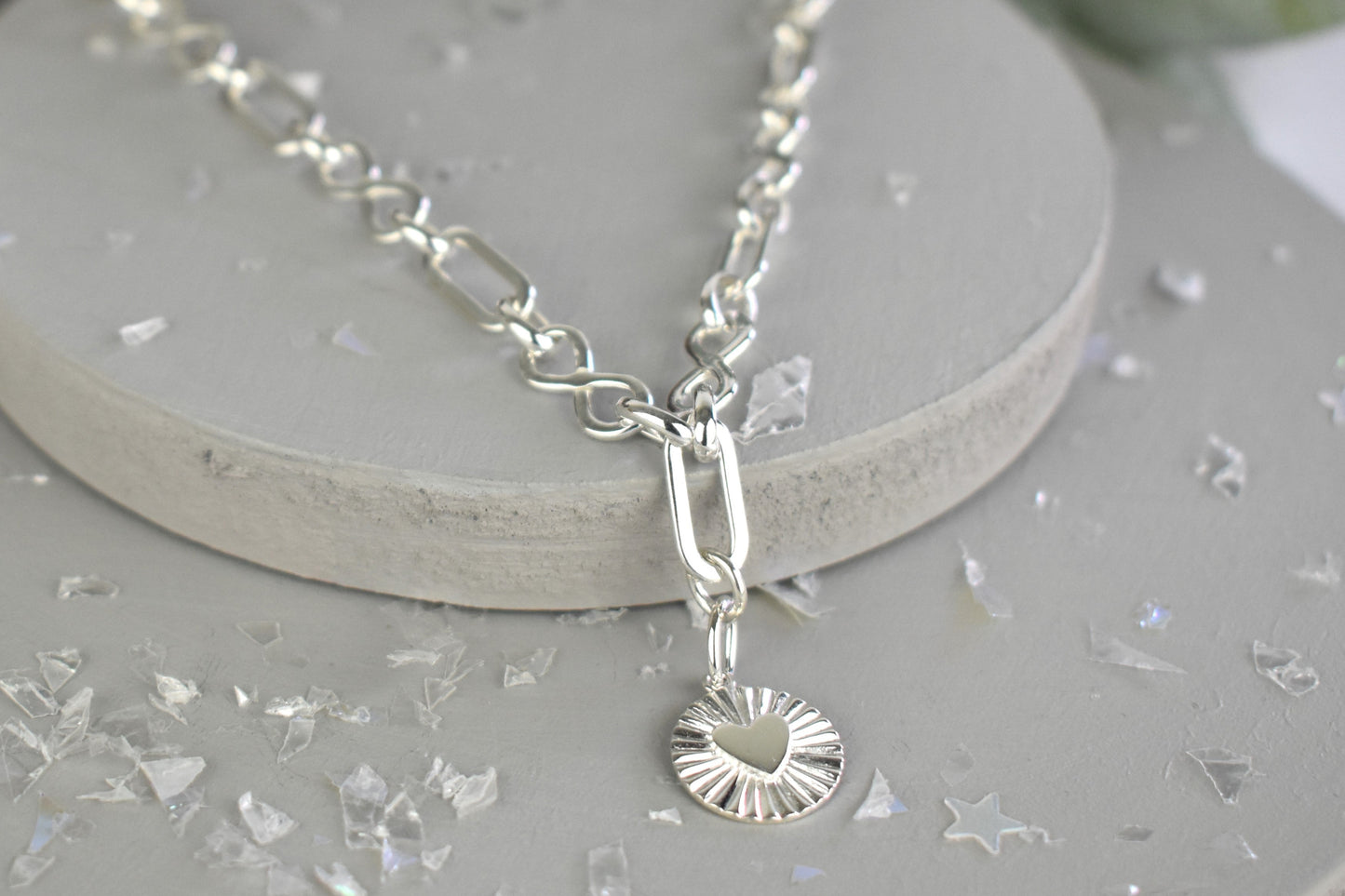 Sterling Silver Handmade Flat Link Infinity Necklace featuring a Heart Rays Pendant. Showcases flat oval and infinity links and features a Sterling Silver Sunburst Heart Rays charm pendant surrounded by an intricate sun rays design