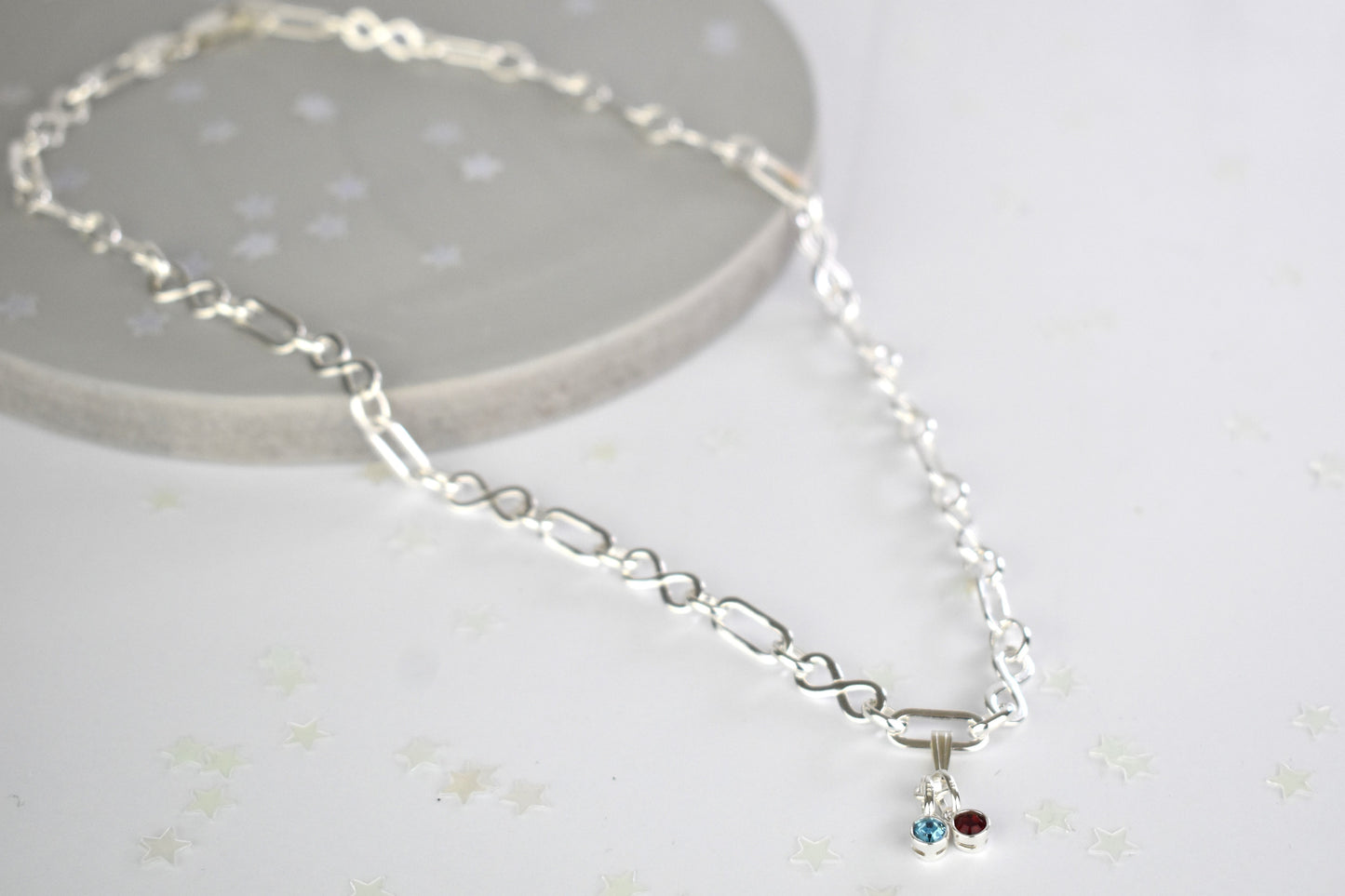 Sterling silver necklace of linked infinity symbols hung with birthstones of your choice