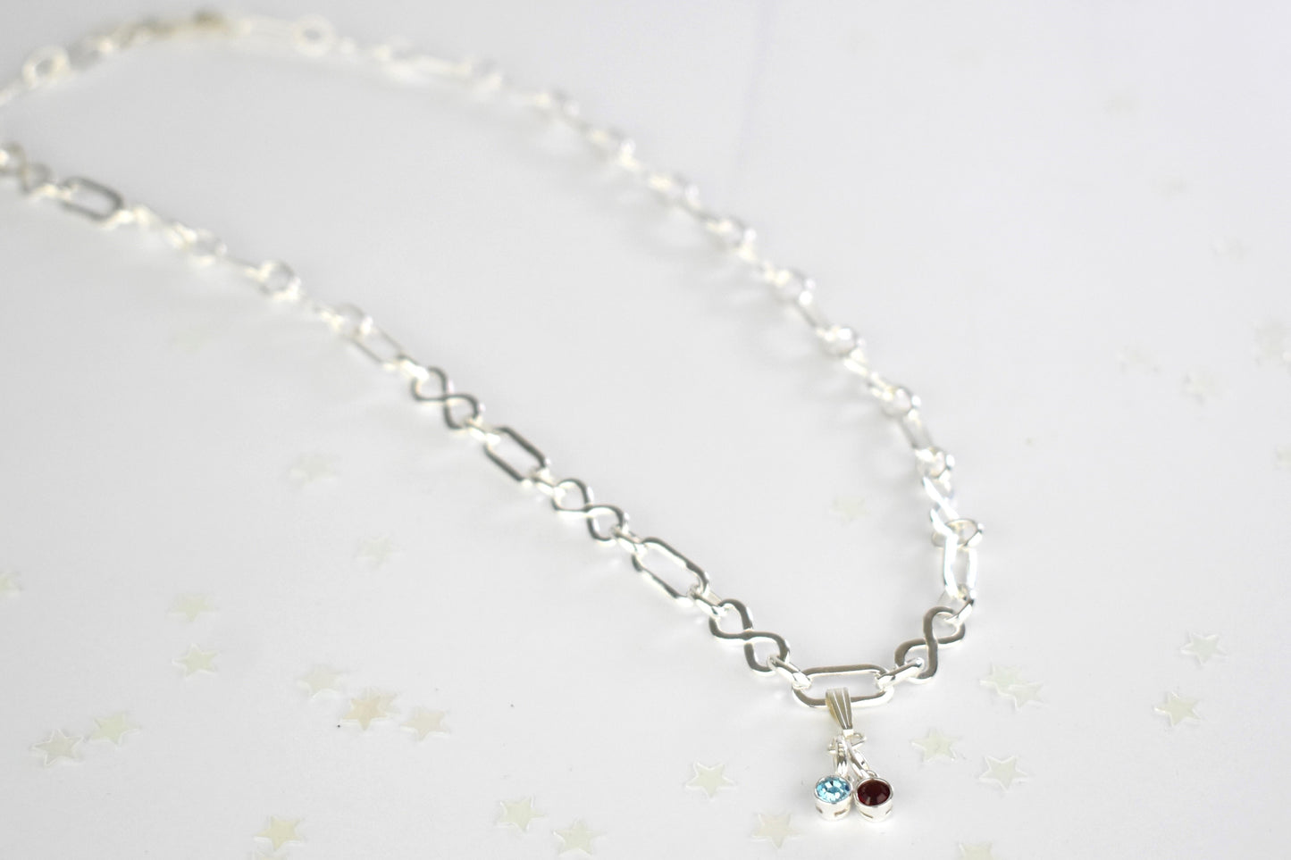 Sterling silver necklace of linked infinity symbols hung with birthstones of your choice