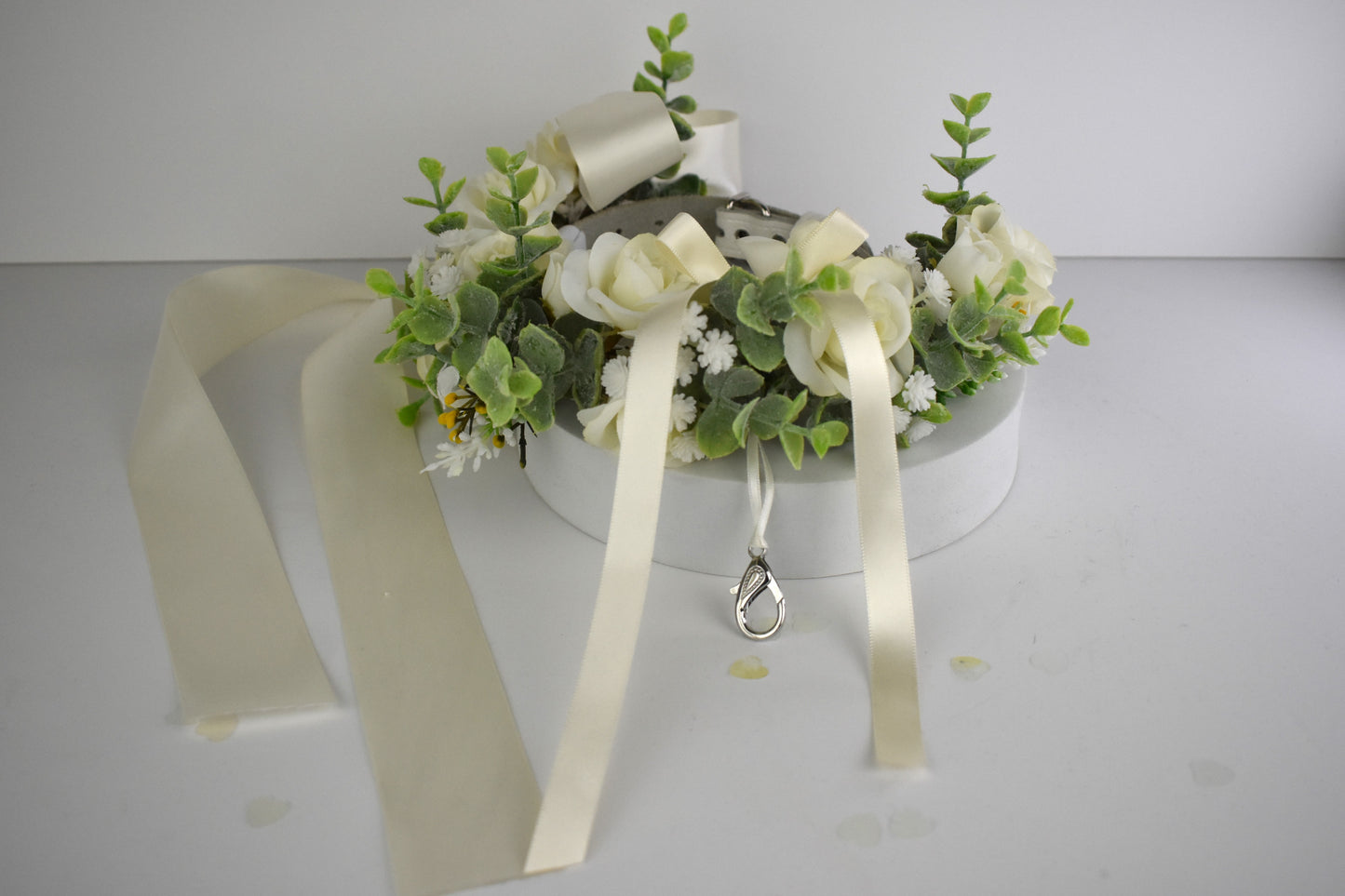 Ivory Silk Dog Ring Bearer Collar. Featuring delicate ivory silk roses and buds with a touch of woodland frosted greenery, this collar is finished with your choice of satin ribbon to match your colour scheme. Optional ring bearer clasp