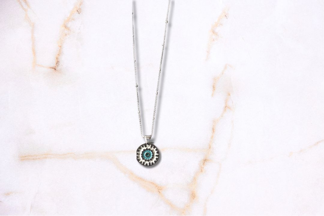 sterling silver Mandala charm with blue enamel hangs on a sparkling sterling silver satellite chain finished with a spring ring clasp.