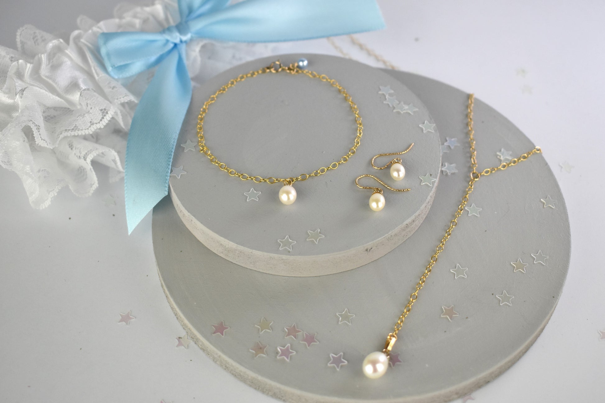 Something blue gift set shown in gold filled finish. Freshwater pearls. on a lariat necklace, chain bracelet both finished with a tiny blue crystal or pearl. Matching freshwater pearl earrings on gold plated wires.