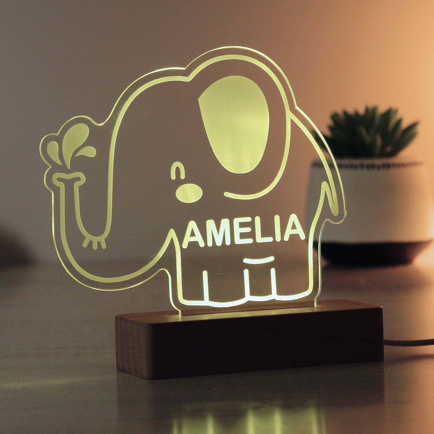 Childs LED light on wooden base. Cartoon elephant personalised with your child's name. Changing or fixed colour and brightness settings. Shown in yellow