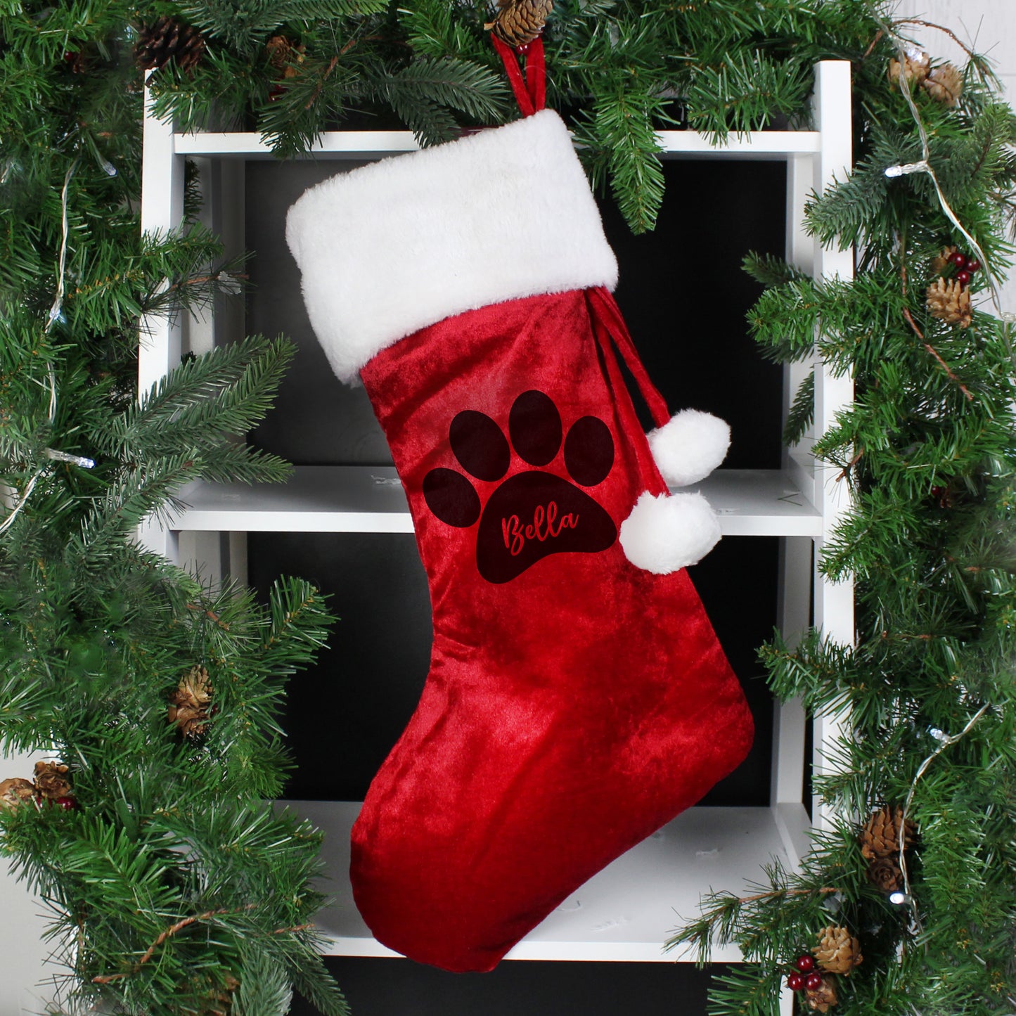 Red velvet Christmas stocking trimmed with whie fur and finished with two white pompoms. There is a paw print on the stock and space within it to add your pet's name.