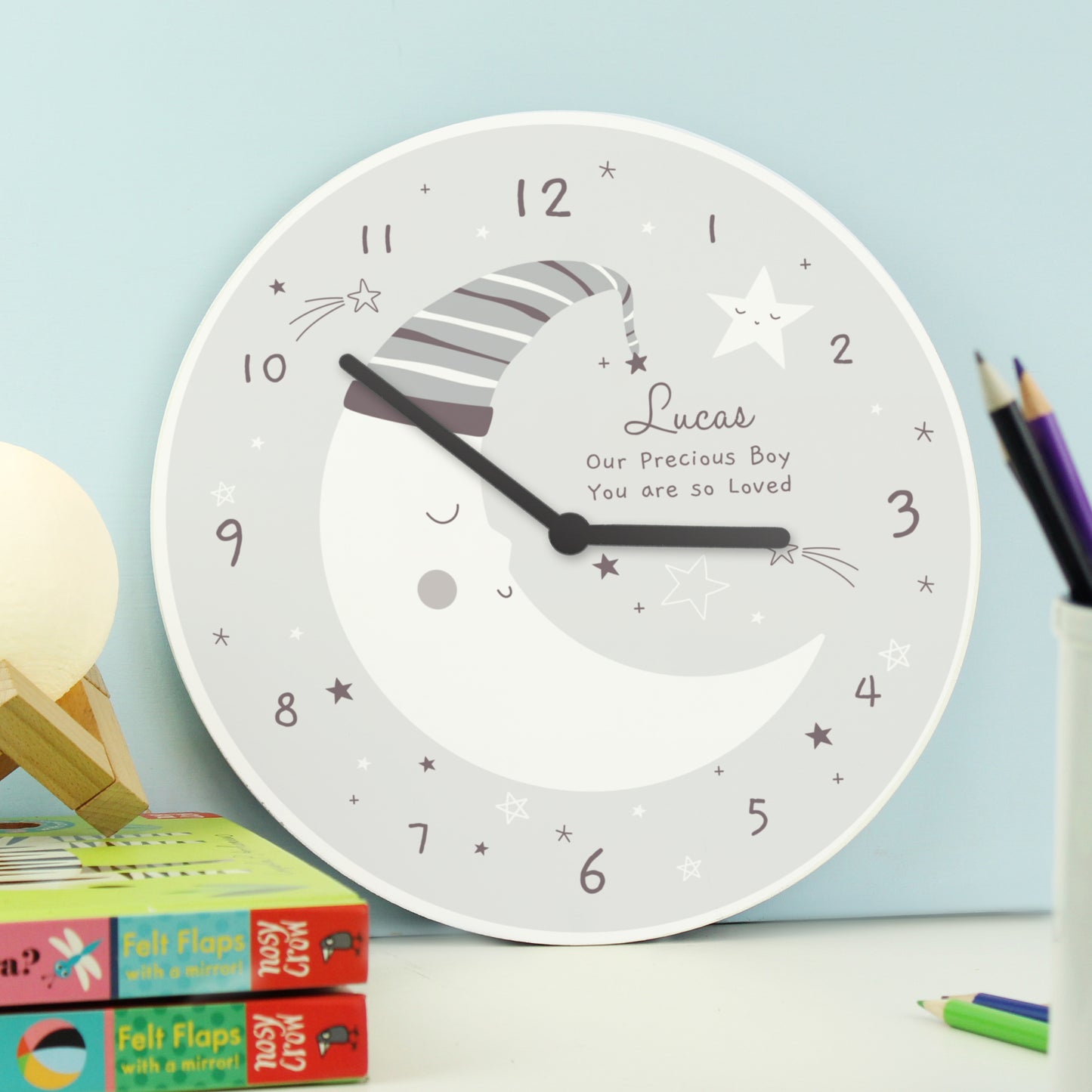 Wooden crescent moon clock with a sleepy moon and star design. Personalise with up to three lines of your own text.
