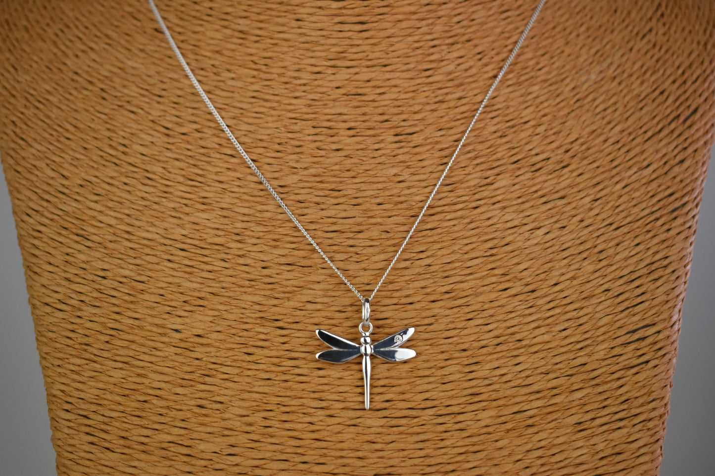 Dragonfly is sterling silver with a sparkling cubic zirconia crystal on its wing. Hangs on a 16 to 18 inch adjustable sterling silver chain.