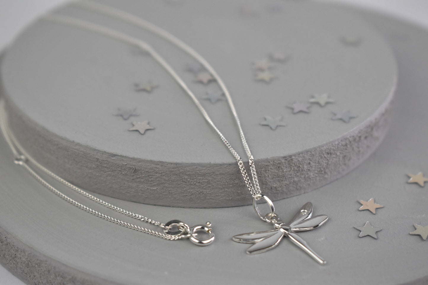 Dragonfly is sterling silver with a sparkling cubic zirconia crystal on its wing. Hangs on a 16 to 18 inch adjustable sterling silver chain.
