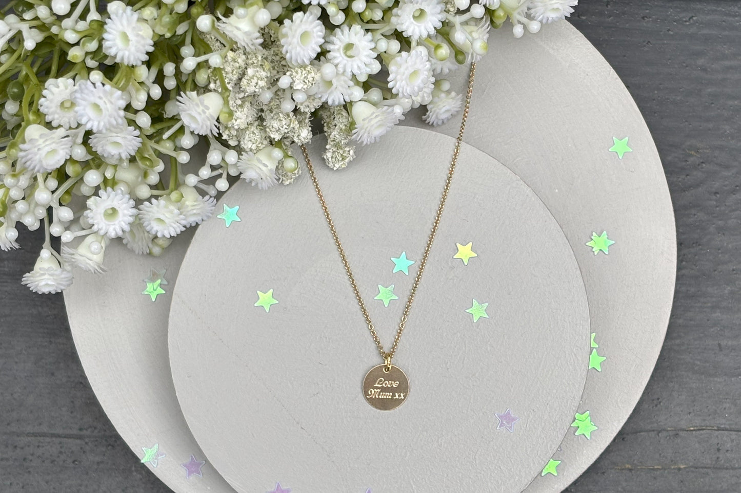 delicate Gold Filled Birth Flower Pendant. Crafted on an 11mm coin pendant, this simple piece is engraved with the intricate design of birth flowers on the front side and on the reverse side features a hidden personalised engraving, making it truly unique.