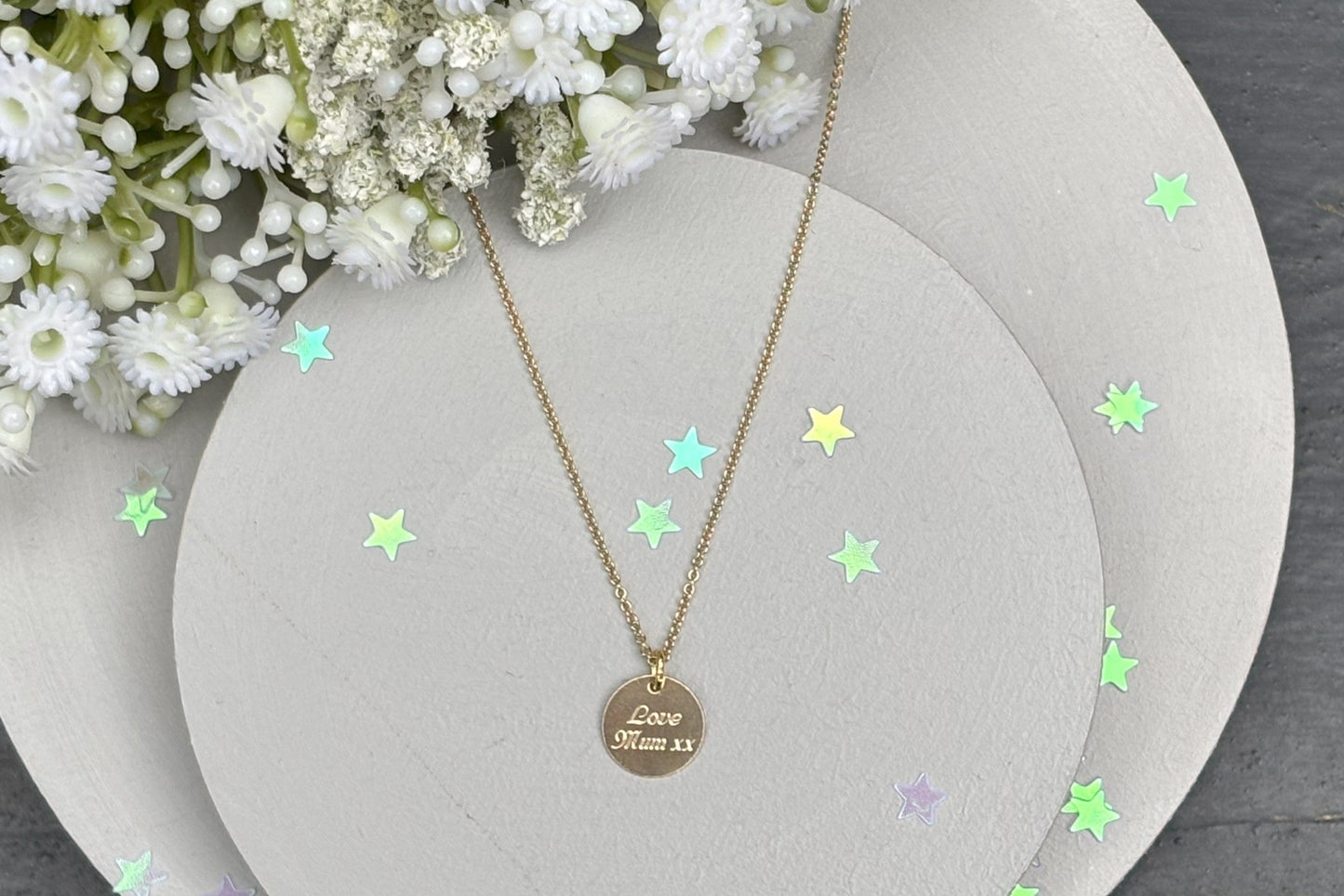delicate Gold Filled Birth Flower Pendant. Crafted on an 11mm coin pendant, this simple piece is engraved with the intricate design of birth flowers on the front side and on the reverse side features a hidden personalised engraving, making it truly unique.