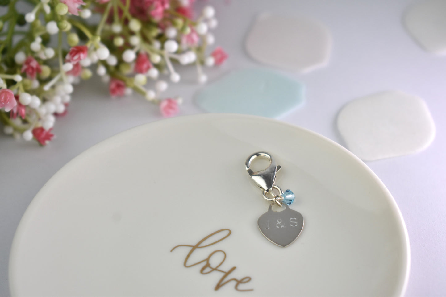 Sterling silver engraved heart and trigger clasp with tiny blue crystal . For Bride's bouquet, shoe, inside the gown or wherever she wishes to use it.