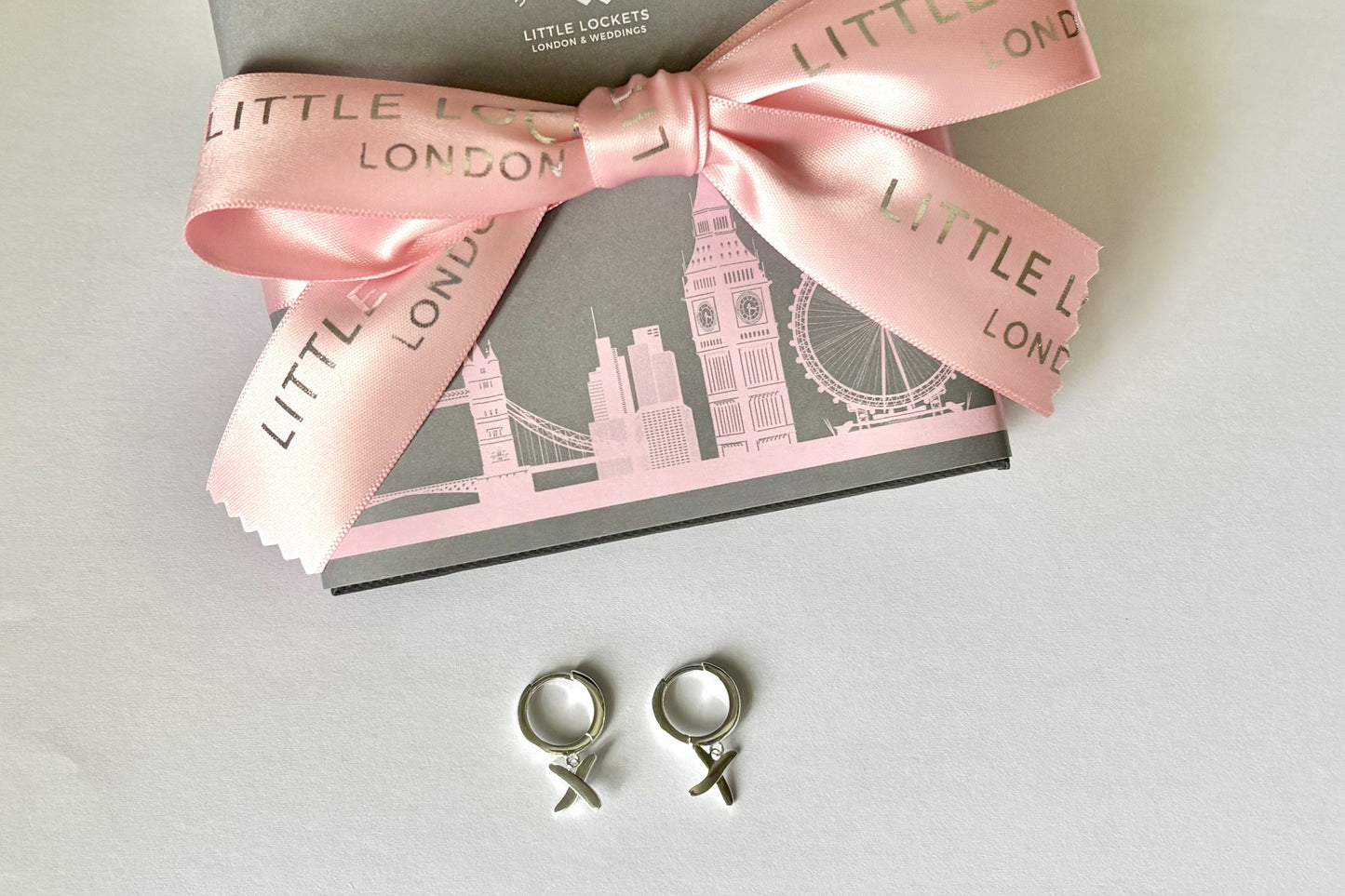 Huggie earrings to match our golden kisses necklace. Shown as 9mm huggies sterling silver have a "kiss" dangling from each earring.