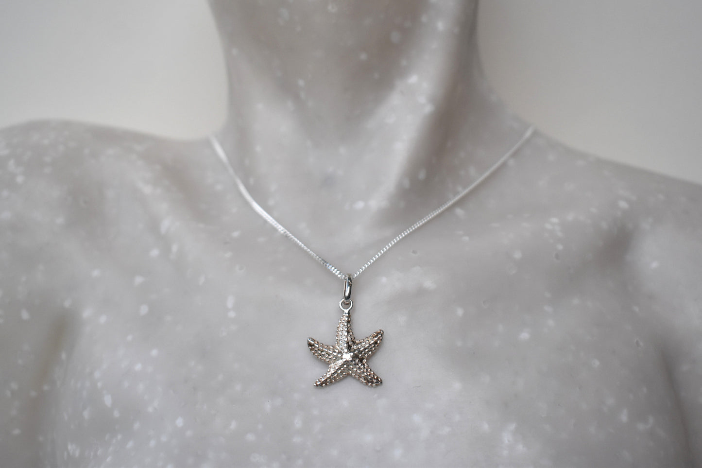sterling silver starfish suspended from an adjustable 16-18" sterling silver chain.