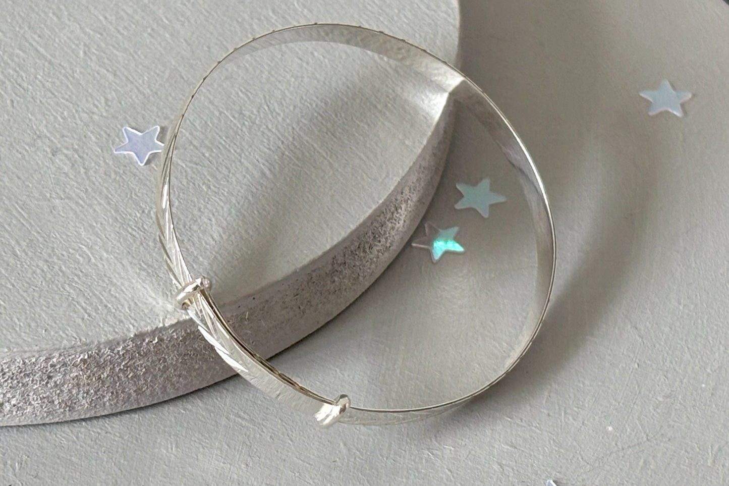 sterling silver expandable baby bracelet features a delicate diamond-cut chevron pattern