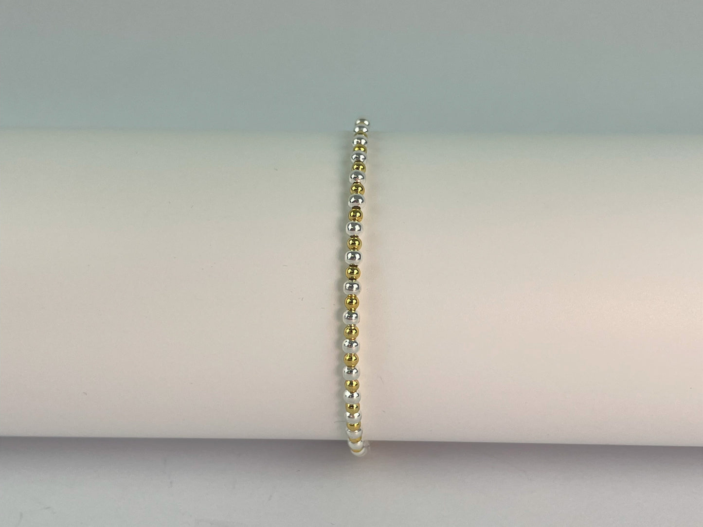 two colour elasticated stacker bracelet made with gold plated and silver plated beads