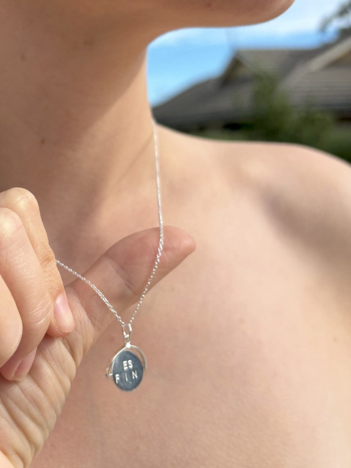 Sterling silver spinner necklace with lettering either side. When spon is forms the words "Best Friend"