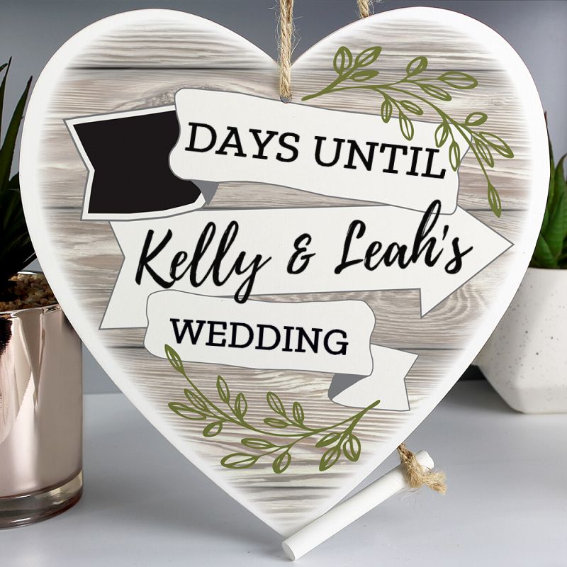 A wooden heart adorned with a wood and leaf finish and a small incorporated chalkboard for you to count down the days to your wedding. Personalised with the names of the happy couple.