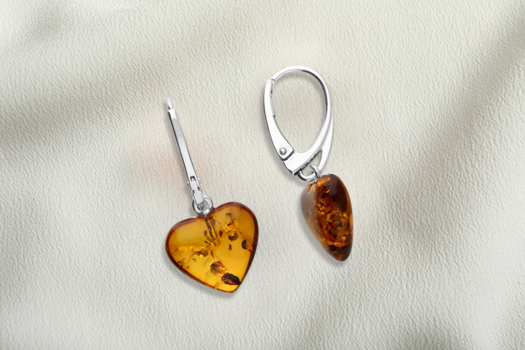 Pair of amber heart-shaped earrings on a light background