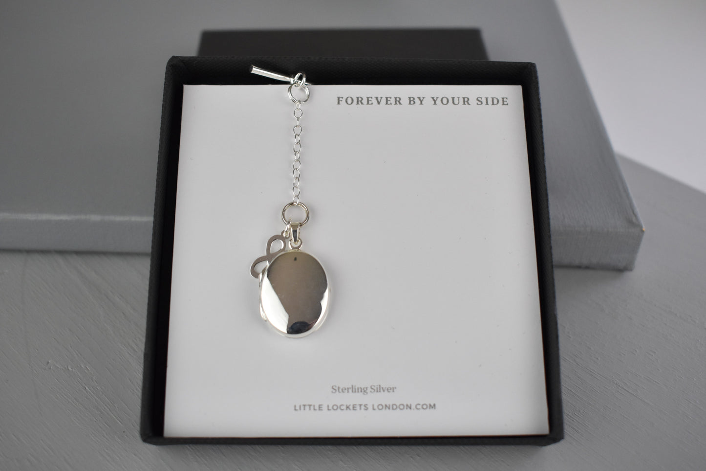 Sterling Silver Men's Photo Locket with a sterling silver Infinity charm. The Infinity charm makes a beautiful statement meaning everlasting, eternal and never-ending. The locket can hold up to two photographs.