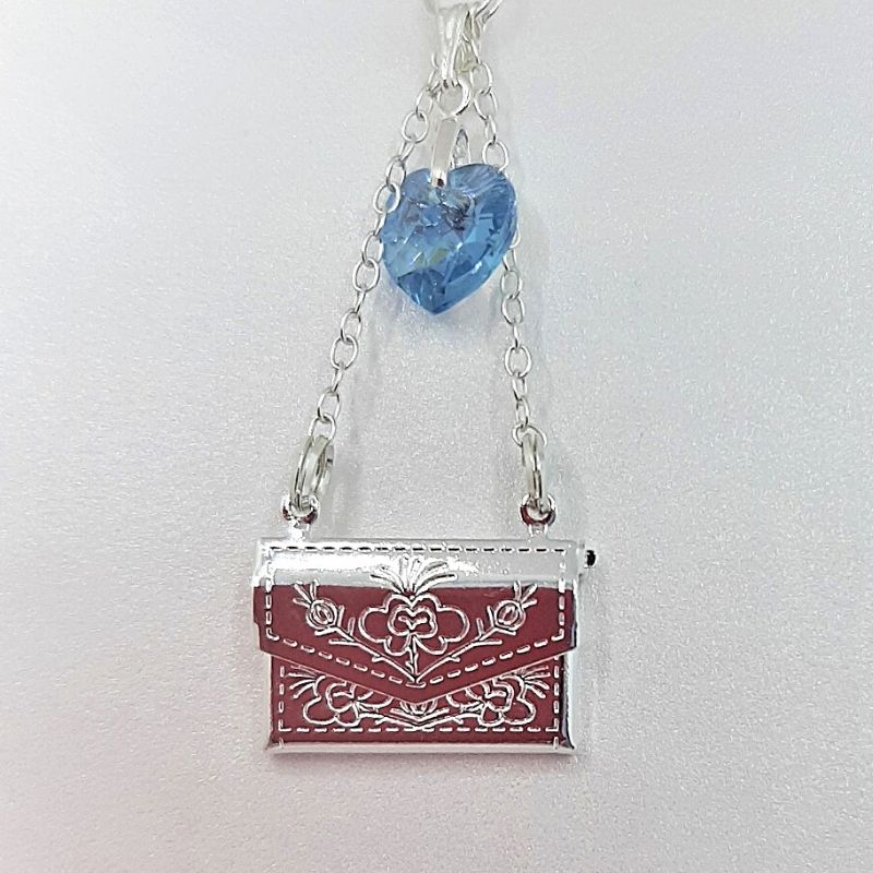 close up of secret message wedding bouquet charm. A silver locket shaped like an envelope for you to add your message inside.