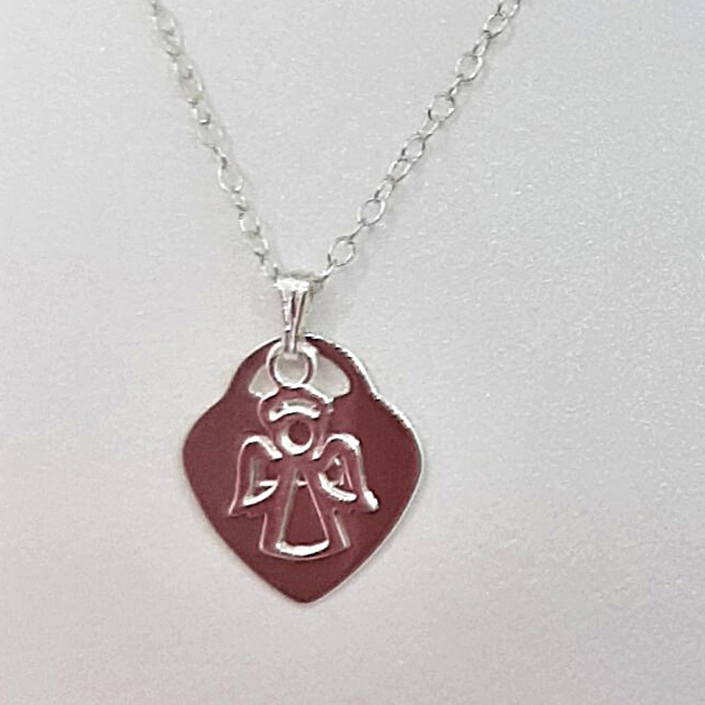 Sterling silver angel charm hung on a pendant with a sterling silver heart. Heart can be engraved with the name of your choice.