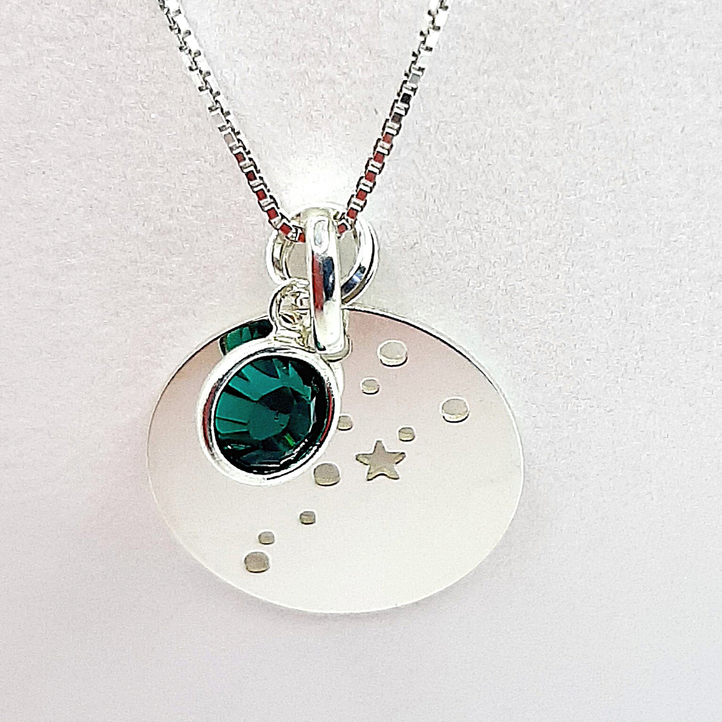 Sterling silver constellation pendant. Silver disc is cut out to show alignment of stars and planets in your birth constellation. Accompanied by a high quality crystal birthstone and suspended from a sterling silver chain