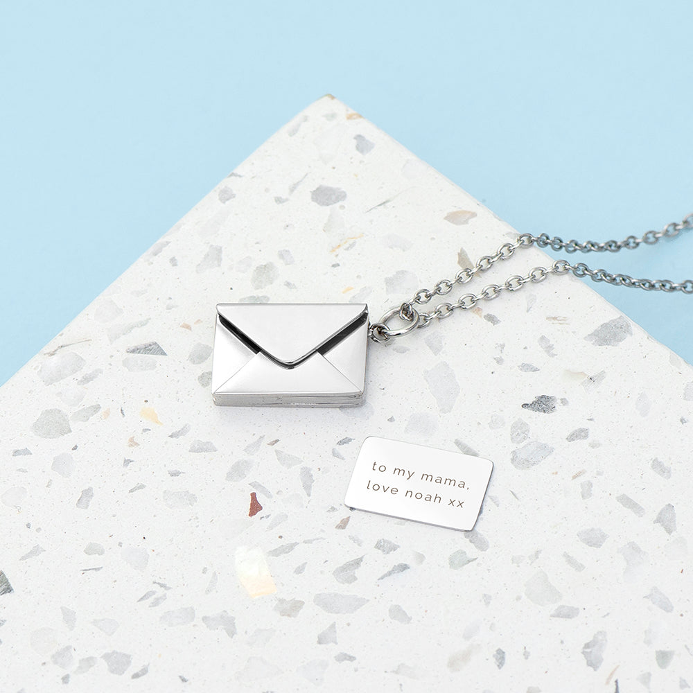 silver plated envelope closed, but with the contents next to it. Content is an engraved note with a message of your choice