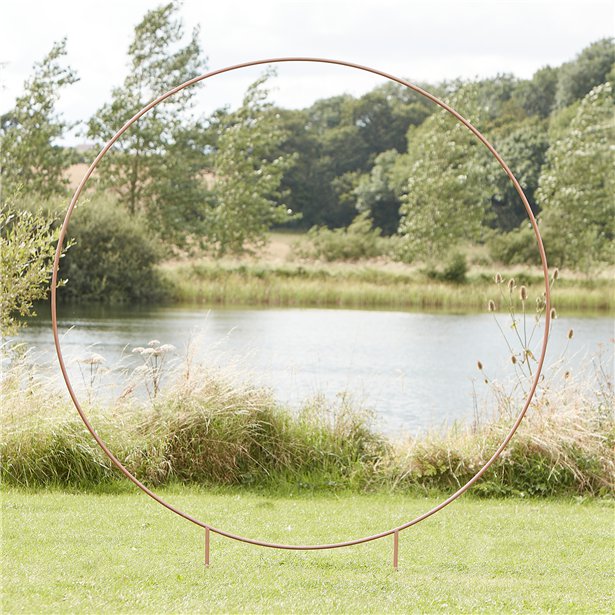 A large copper hoop that is free standing and can be used for flower or balloon displays.